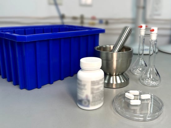White dietary supplement capsules on a table in preparation for laboratory testing. 