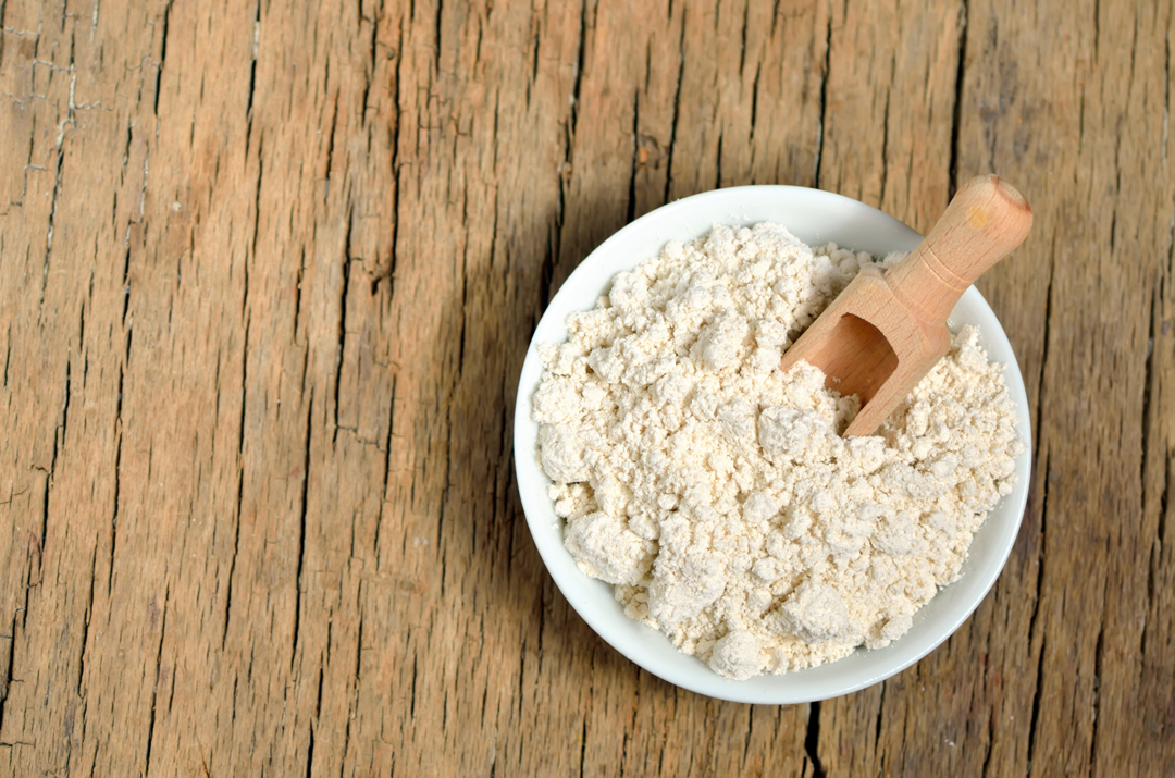 Oatmeal in a bowl with a wooden scoop. 